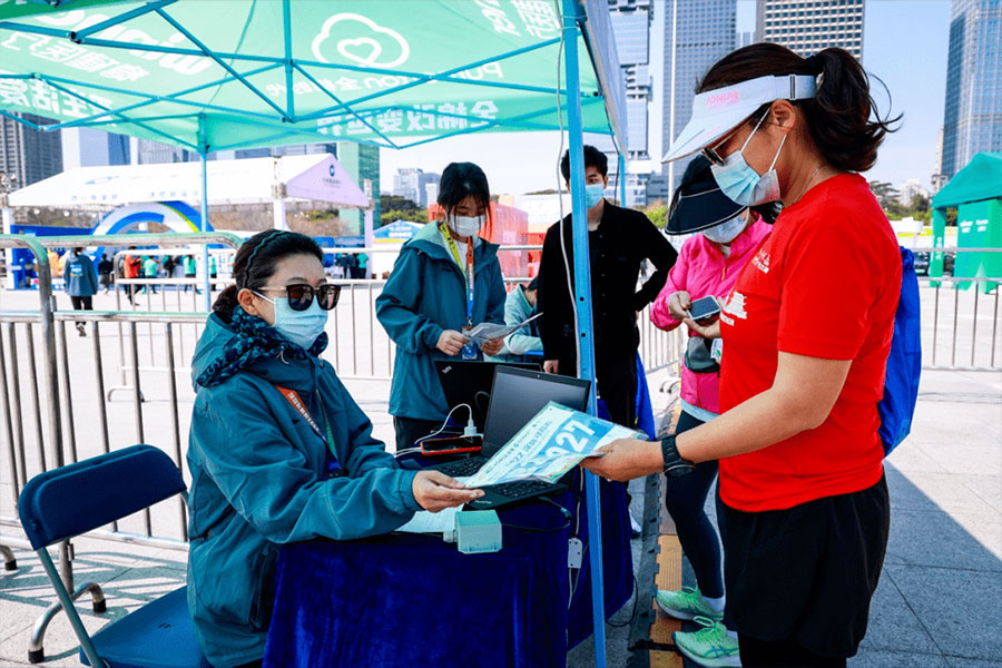 Participants of the Shenzhen Marathon receive their RFID number bibs and activate RFID chips